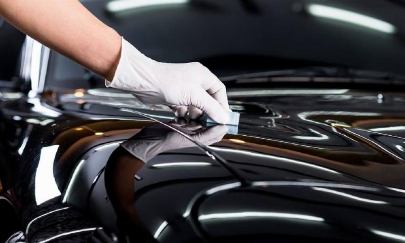 Một kỹ thuật viên đang kiểm tra hệ thống treo của xe ô tô tại trung tâm dịch vụ